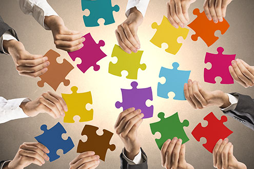 Concept of teamwork and integration with businessman holding colorful puzzle