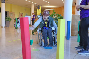 Ein Bewohner im Rollstuhl wirft mit einem Säckchen eine Schaumstoffsäule um.