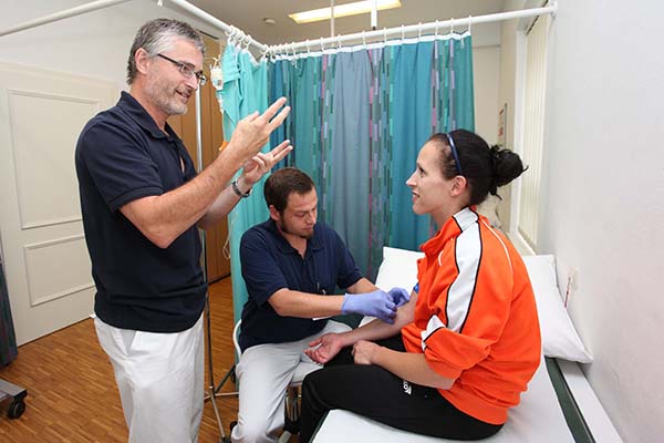 Arzt, Pfleger und Patientin bei einer Untersuchung