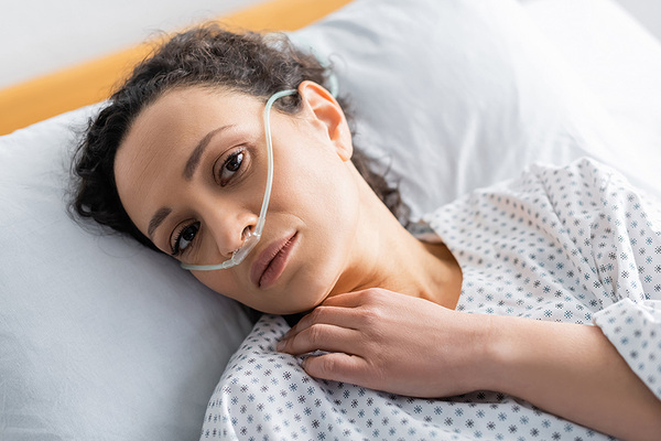 Das Bild zeigt eine Frau in einem Krankenbett.