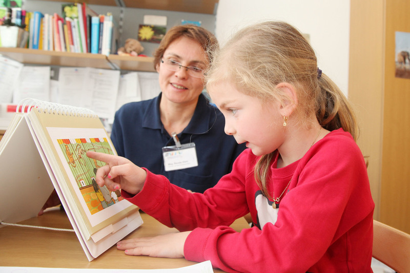 Das Foto zeigt ein Kind bei der Sprachtherapie mit einer Therapeutin.