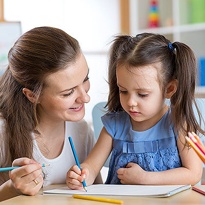 Das Bild zeigt eine Elementarpädagogin und ein Kind.